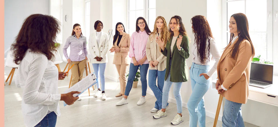 A group of young women chatting together in a bright workshop space